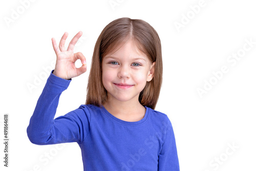 Smiling child showing sign OK, isolated on white background looking at camera waist up caucasian little girl of 5 years in blue