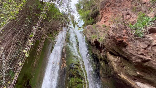 Waterfall in the forest with rocks covered in moss photo