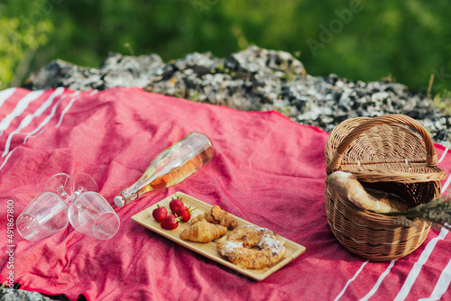 Fototapeta Naklejka Na Ścianę i Meble -  Cozy summer picnic at nature. Romantic picnic with croissants, strawberries, cheese and white wine. 