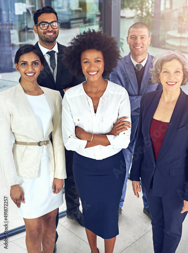 Teamwork enables smoother movement towards targets. Portrait of a team of corporates standing together in an office. photo