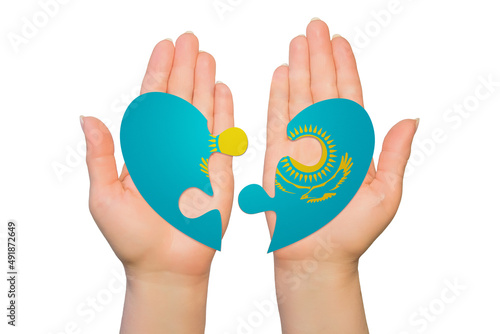 Woman hands are holding two parts of puzzle heart. National concept on white background. Kazakhstan