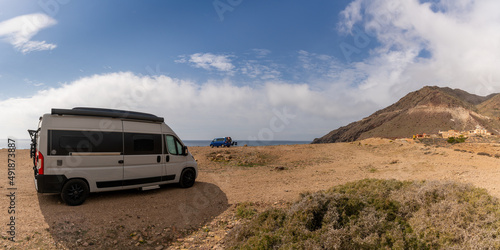 camper vans parked on a rocky beach on the wild coast of Andalusia