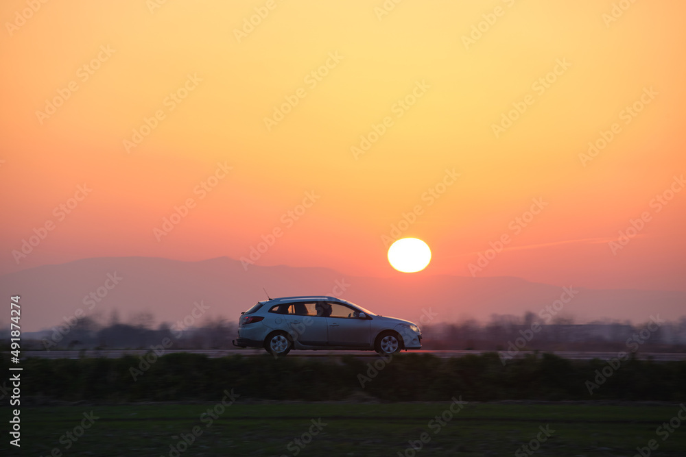 Car driving fast on intercity road at sunset. Highway traffic in evening Car driving fast on intercity road at sunset. Highway traffic in evening