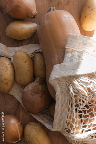 close-up of net bag with pumpkins, potatoes and onions.