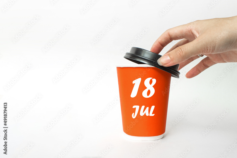 Fototapeta premium July 18th. Day 18 of month, Calendar date. A woman's hand open black plastic cap of red disposable cardboard coffee paper cup with Calendar Date. Summer month, day of the year concept.