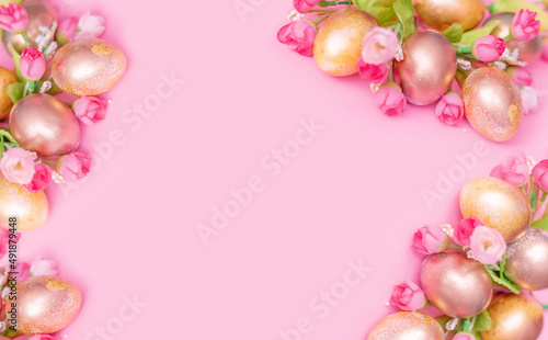 Golden Easter eggs with flowers on a pink background . Easter concept with space for text