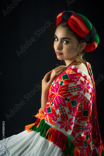 Mexican teenager dressed in Huasteca Potosina costume from the state of San Luis Potosí Mexico, traditional embroidery and multicolored yarn petob photo