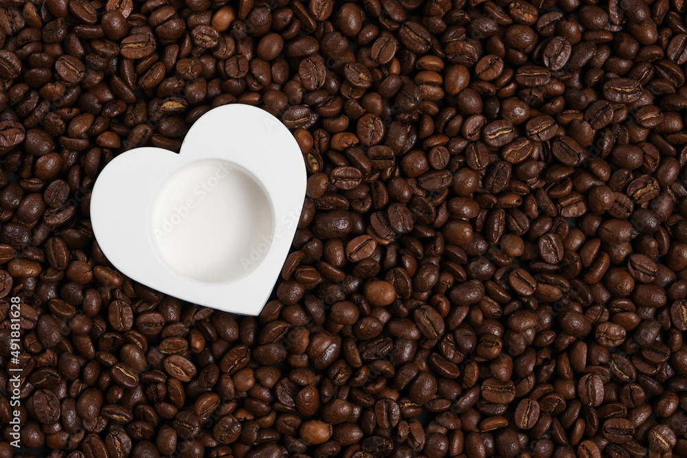 Fototapeta premium White heart on the background of roasted coffee beans.