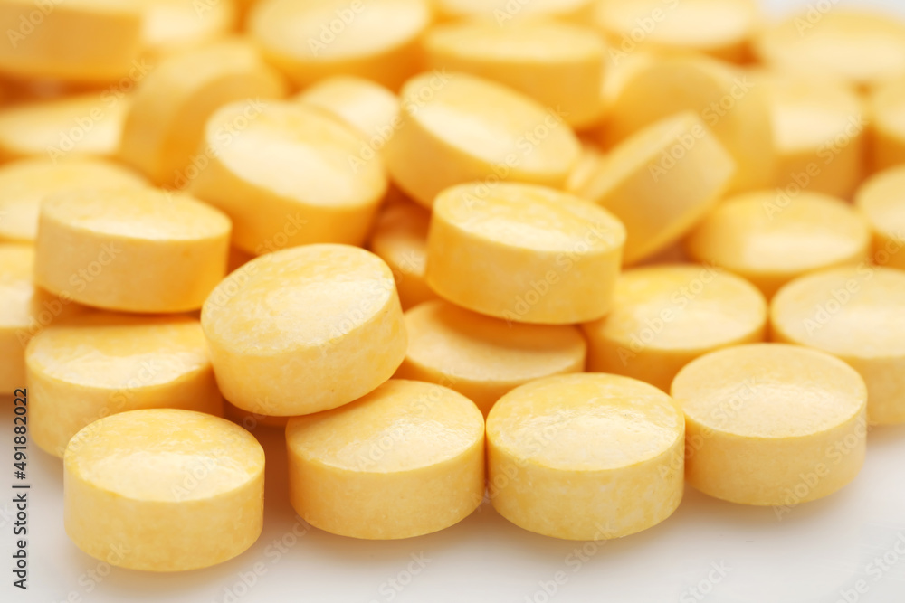 Yellow pills on white background, closeup Yellow pills on white background, closeup