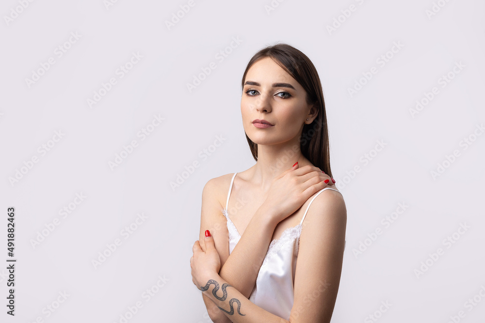 Fototapeta premium Beautiful smiling woman with clean skin, natural make-up and white teeth on a gray background