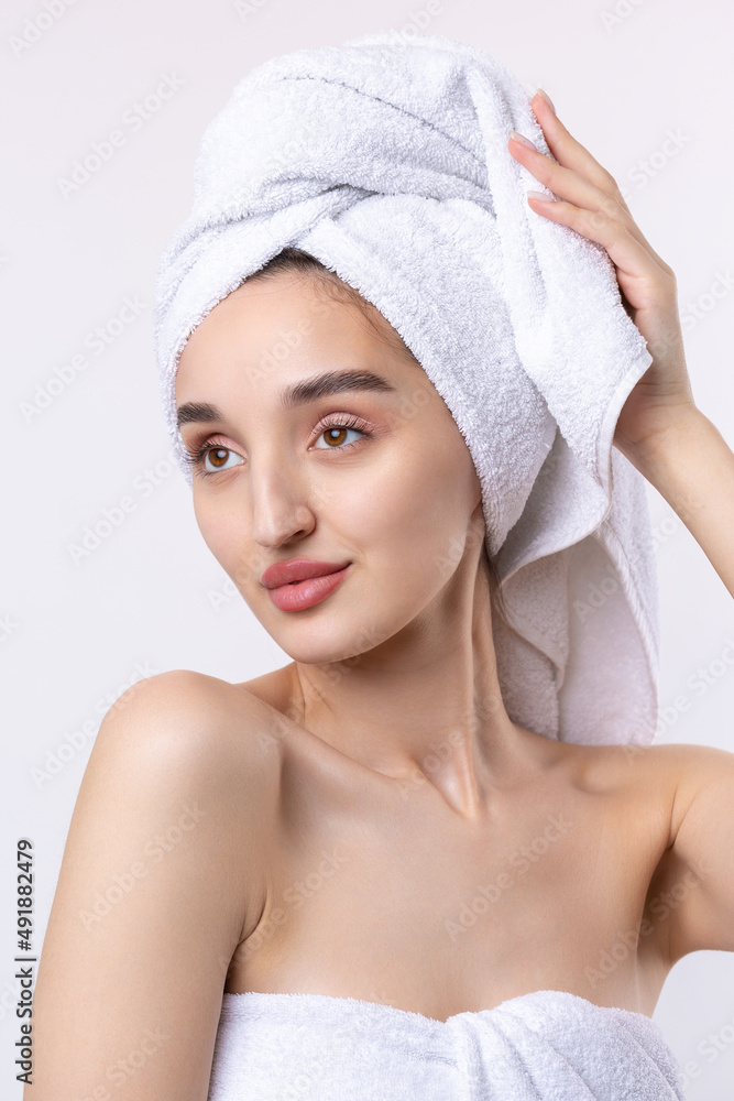 Beautiful girl with thick eyebrows and perfect skin at white background, towel on head, beauty photo. Beautiful girl with thick eyebrows and perfect skin at white background, towel on head, beauty photo.