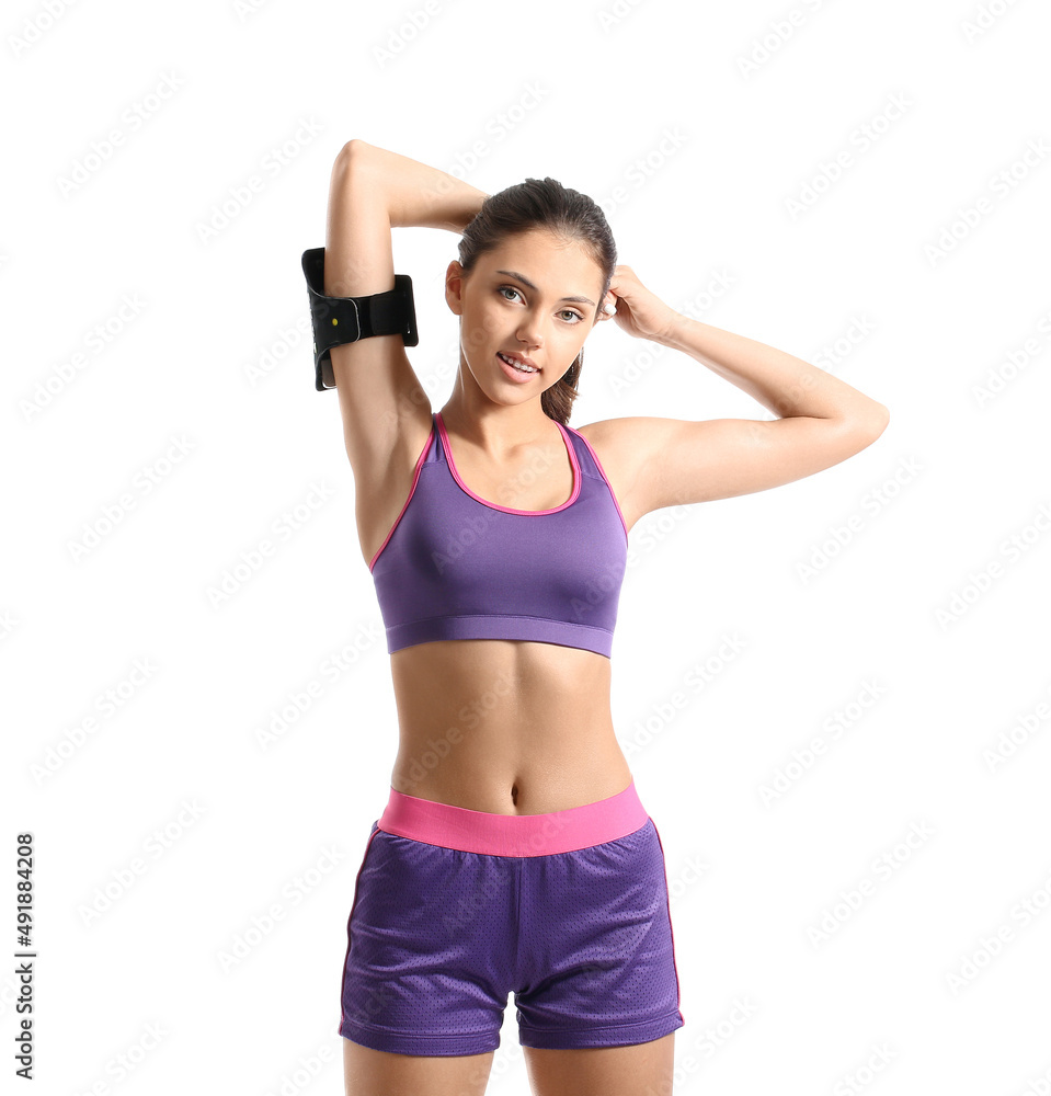Sporty teenage girl with armband on white background