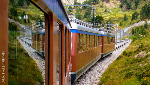 Famous narrow gauge gear train “Gornergrat-Bahn“ descending from mountain station with viewpoint. Matterhorn Panorama near Zermatt Switzerland. Historic railcar multiple unit near Riffelalp (2006)