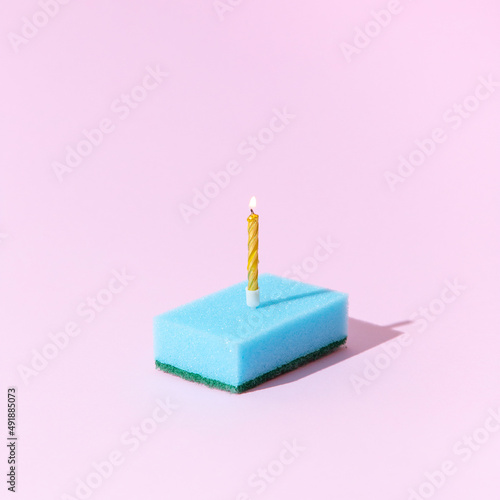 Cleaning sponge as a birthday cake with candle. Creative concept.