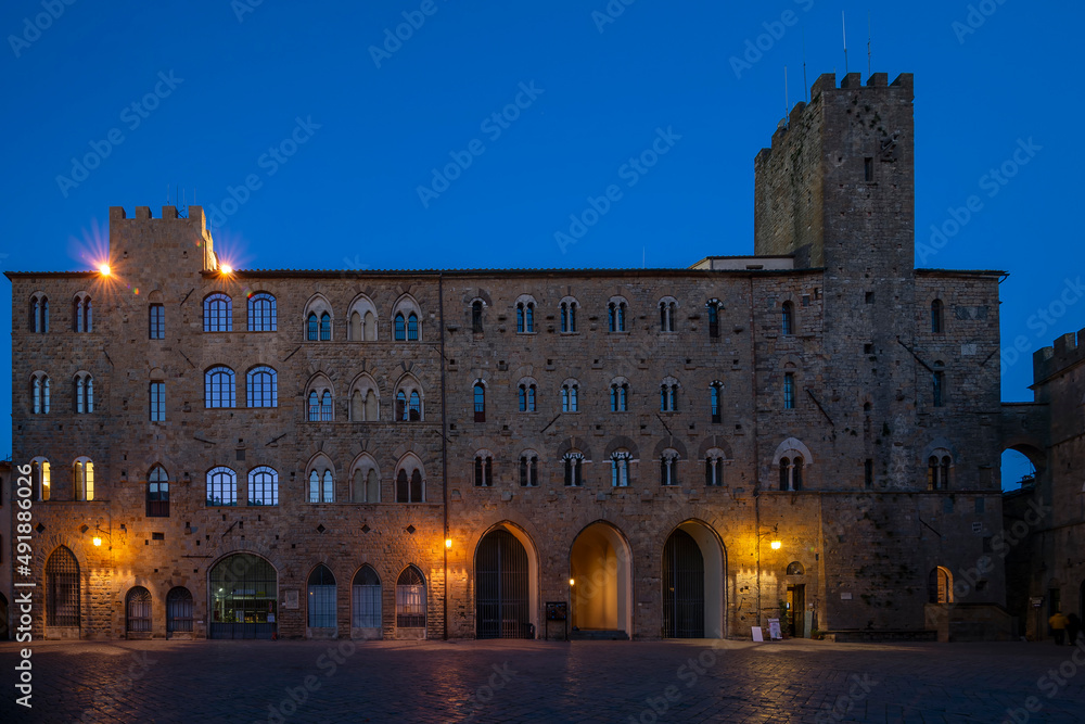 Pretorio Palace, Porcellino Tower and Priori Square in a quiet moment of the evening with the blue light, Volterra, Pisa, Tuscany, Italy