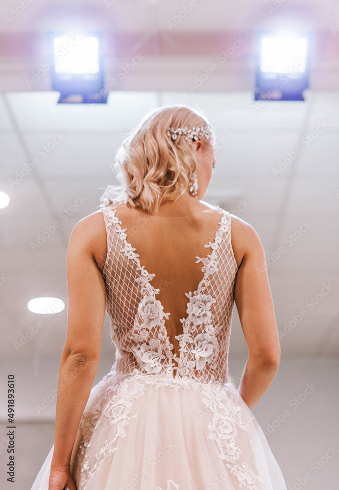 Bride in open back dress posing in bridal salon