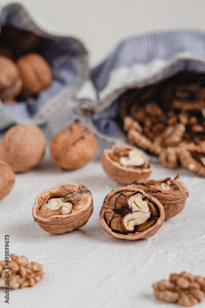 Many walnut kernels in eco bag on a white background. Walnuts are good for the brain. Healthy eating concept. Many walnut kernels in eco bag on a white background. Walnuts are good for the brain. Healthy eating concept.