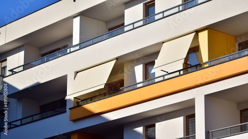 Modern architecture building facade with awnings. Balcony with awning opened  covered by sun-shield. 