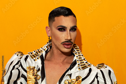 Fotografie Portrait of beautiful drag queen with piercing eyes on yellow background