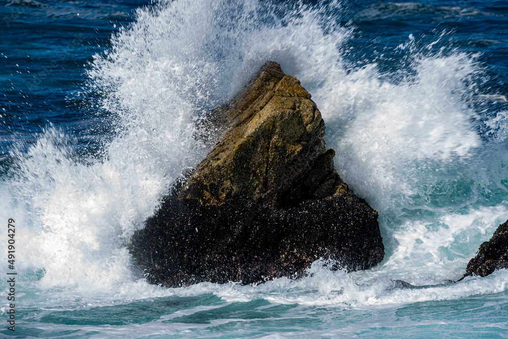Naklejka premium wave breaking on the rocks