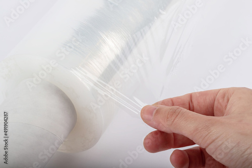 Roll of plastic stretch film with clear wrap. how long the roll of cling film can stretch is shown. It stands in an isolated environment. It is used in the packaging of products.
