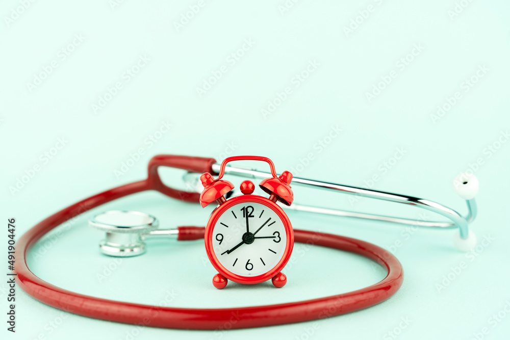 stethoscope with red clock on blue background copy space stethoscope with red clock on blue background copy space