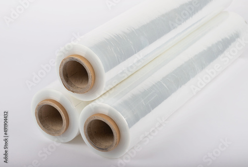 Roll of plastic stretch film with clear wrap. It stands in an isolated environment. It is used in the packaging of products. Overlapping stretch films