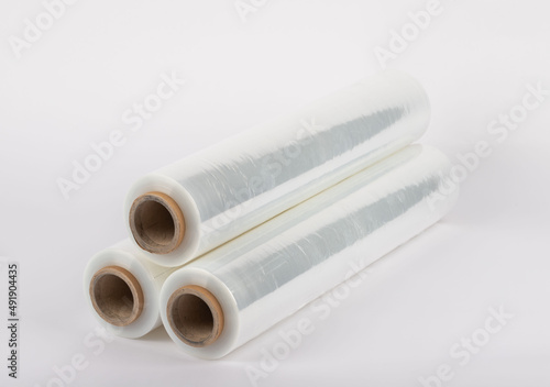 Roll of plastic stretch film with clear wrap. It stands in an isolated environment. It is used in the packaging of products. Overlapping stretch films