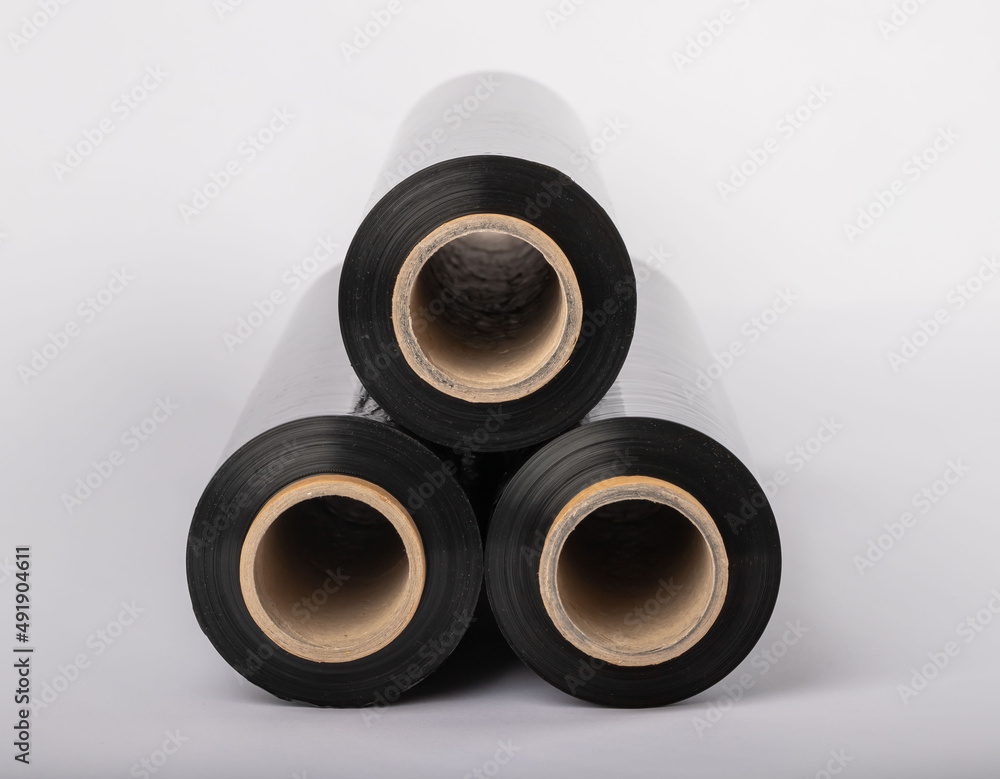 Roll of plastic cling film with black wrap. how long the roll of cling film can stretch is shown. It stands in an isolated environment. It is used in the packaging of products. Roll of plastic cling film with black wrap. how long the roll of cling film can stretch is shown. It stands in an isolated environment. It is used in the packaging of products.