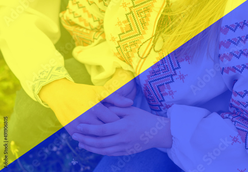 people holding hands on the background of the Ukrainian flag