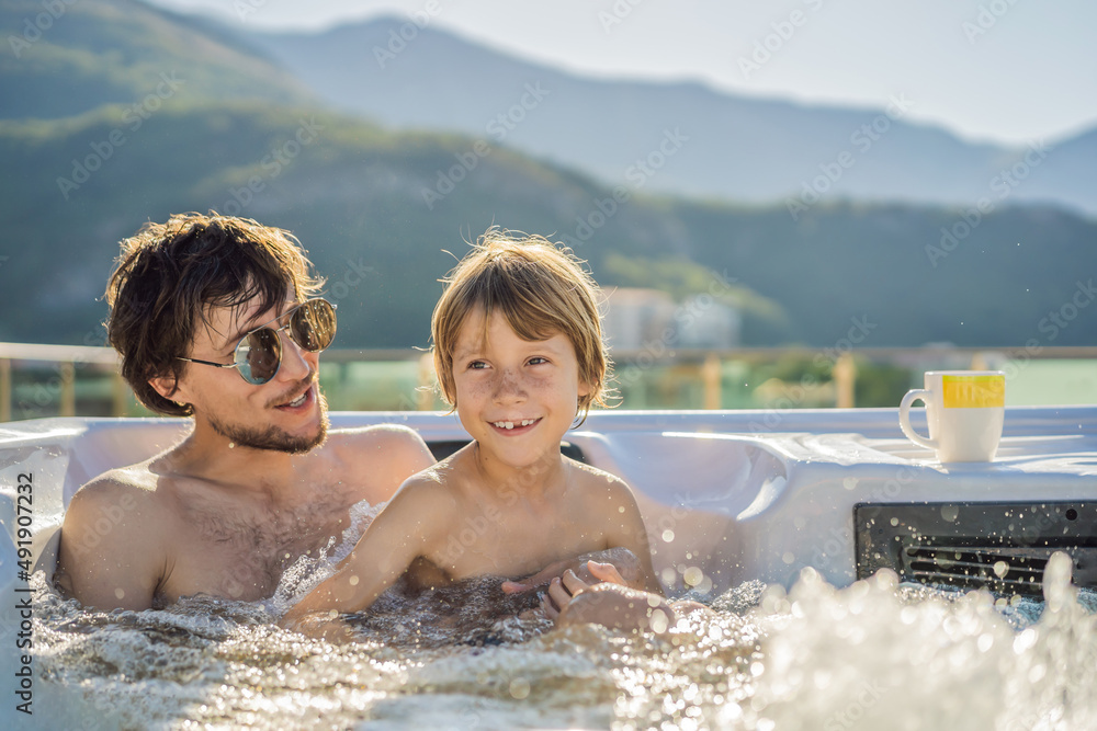 Portrait of young carefree happy smiling happy family relaxing at hot tub during enjoying happy traveling moment vacation. Life against the background of green big mountains