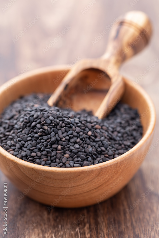 Bio natural black sesame seeds on wooden bowl. Bio natural black sesame seeds on wooden bowl.