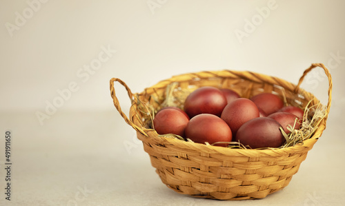 easter eggs in a wicker basket on white background