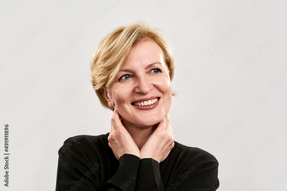 Smiling mature woman touch herself and look away Smiling mature woman touch herself and look away