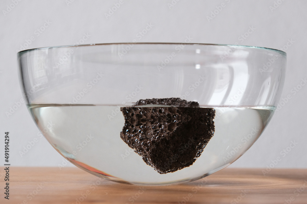 Φωτογραφία floating pumice rock in glass bowl on table