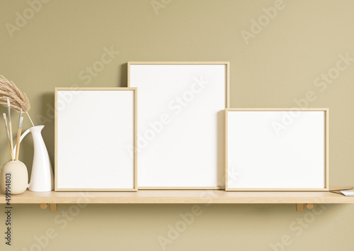 Boho home three horizontal and vertical 8x10 Frames mockup. Horizontal and vertical wood frames on a shelf with a plant in a vase. On a olive green wall. 3d rendering.
