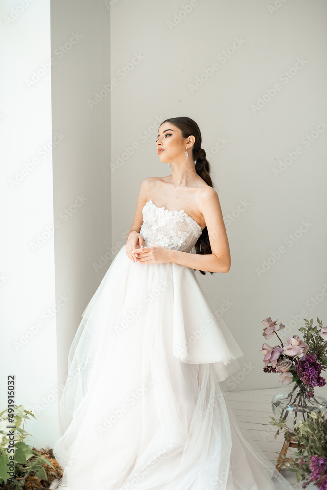 Gorgeous, brunette bride in a white luxurious dress posing Gorgeous, brunette bride in a white luxurious dress posing