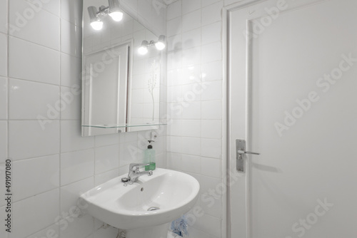Toilet with glass shower stall  white porcelain sink in vacation rental apartment