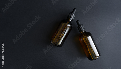 Cosmetics packaging branding mockup template black scowl, dropper, brown bottle dispenser, packaging and branding items. Blank isolated on black background to place your design. Cosmetics without a la