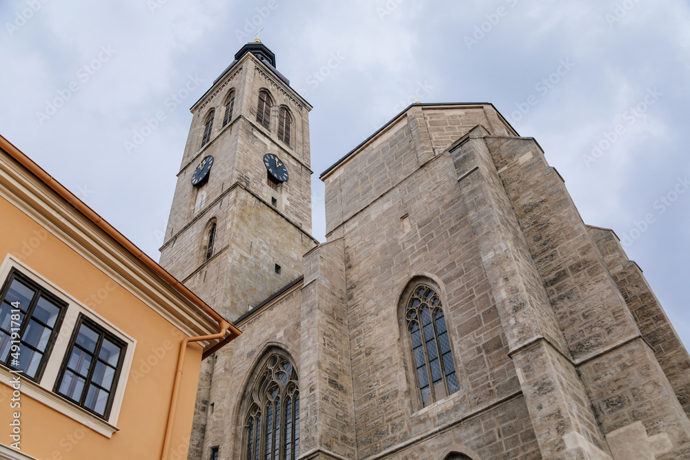 Kutna Hora, Central Bohemian, Czech Republic, 5 March 2022: Gothic stone Church of St. James or Kostel sv. Jakuba with bell and clock tower, medieval architecture at old town, lancet windows