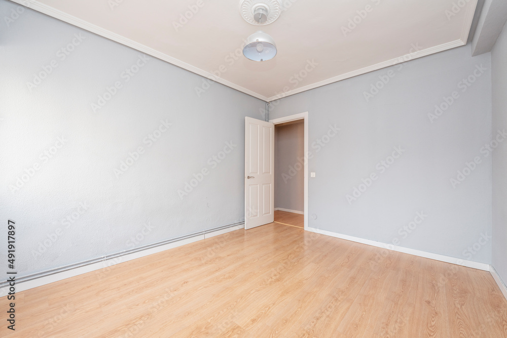 Empty living room with hardwood floors, gray painted walls, plaster molding ceiling, and white woodwork Empty living room with hardwood floors, gray painted walls, plaster molding ceiling, and white woodwork