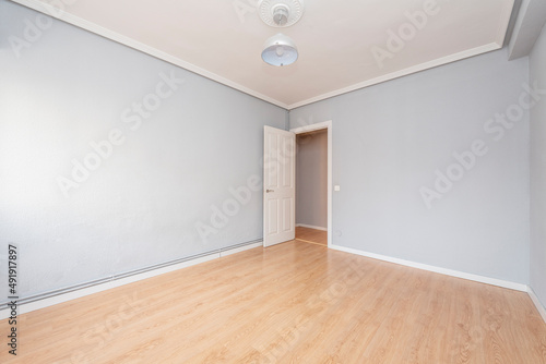 Empty living room with hardwood floors  gray painted walls  plaster molding ceiling  and white woodwork