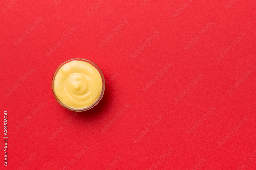Bowl of cheese sauce on colored background, top view with copy space Bowl of cheese sauce on colored background, top view with copy space