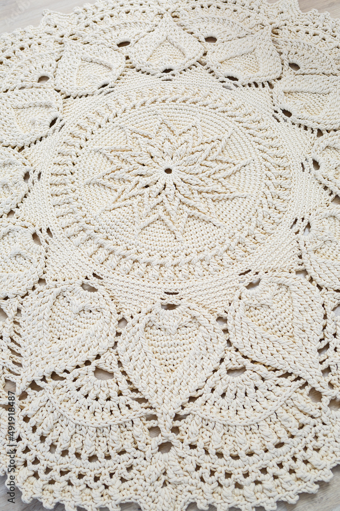 Fototapeta Handmade carpet knitted from natural threads, flooring, natural cotton. Beige handmade carpet. Knitted decorative item