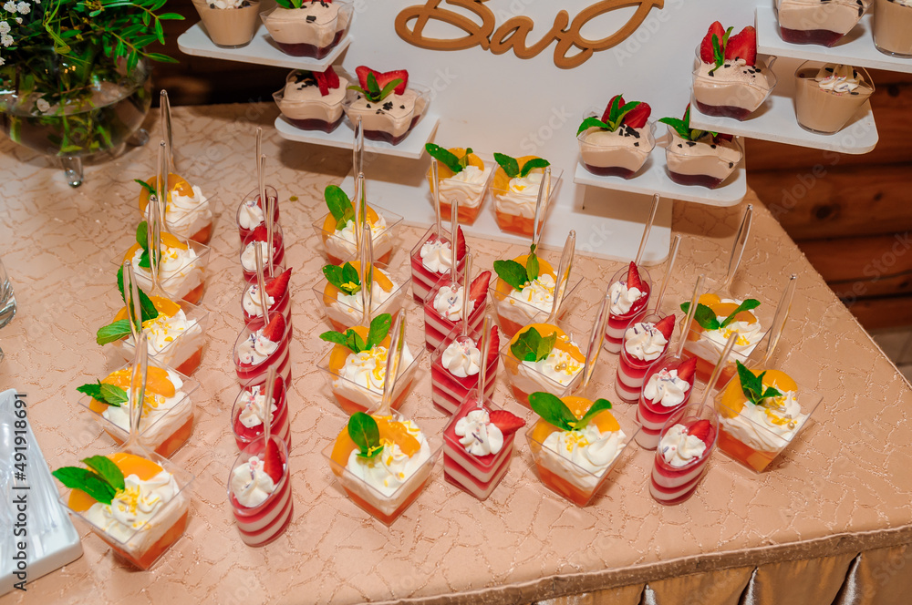 Sweet cakes in cups at a wedding buffet. Candy bar catering