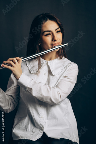 beautiful young woman playing flute. High quality photo