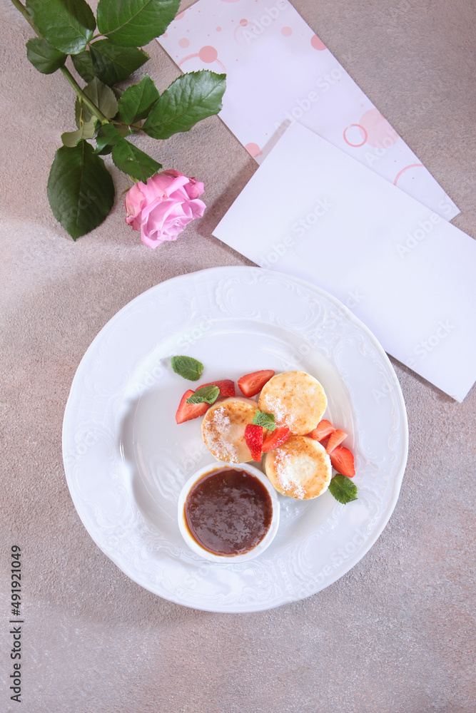 Healthy and delicious breakfast. Cheesecakes with jam and fresh strawberries .A greeting card.An empty space for the inscription on the postcard.Flat lay.