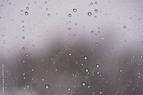 Raindrops on a window with a blurry background 