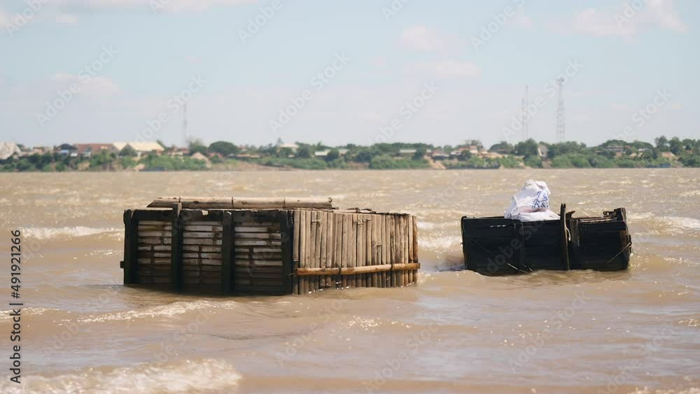 High winds and heavy current river; Waves hitting wooden fish crates ( close up ) High winds and heavy current river; Waves hitting wooden fish crates ( close up )
