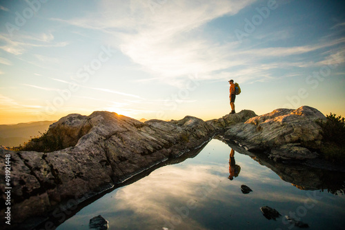 confident backpacker standing on summit ridge, Vancouver B.C. photo